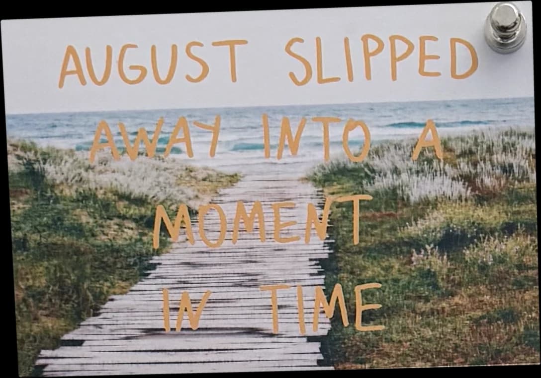 Card held by a magnet, reading August slipped away into a moment in time