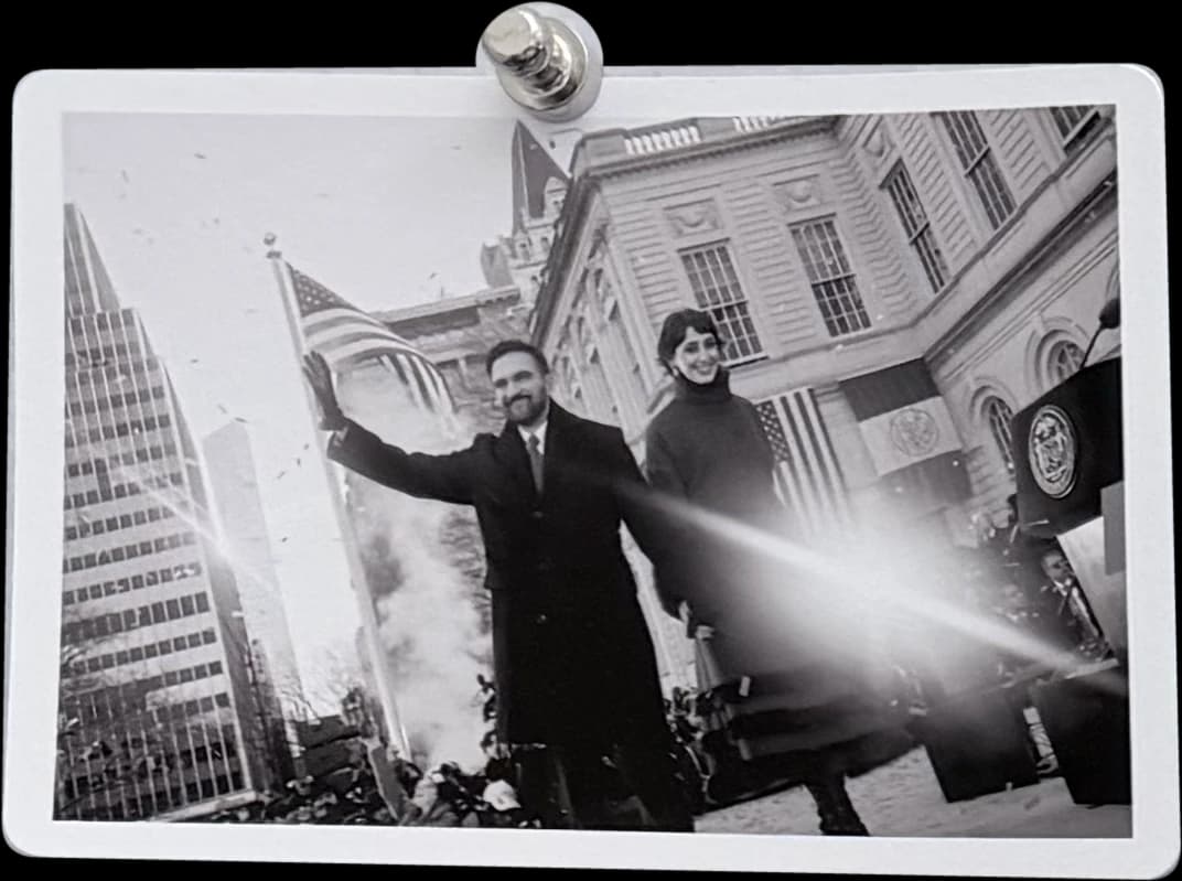 Black-and-white print of Mamdani waving outside New York City Hall, held by a magnet