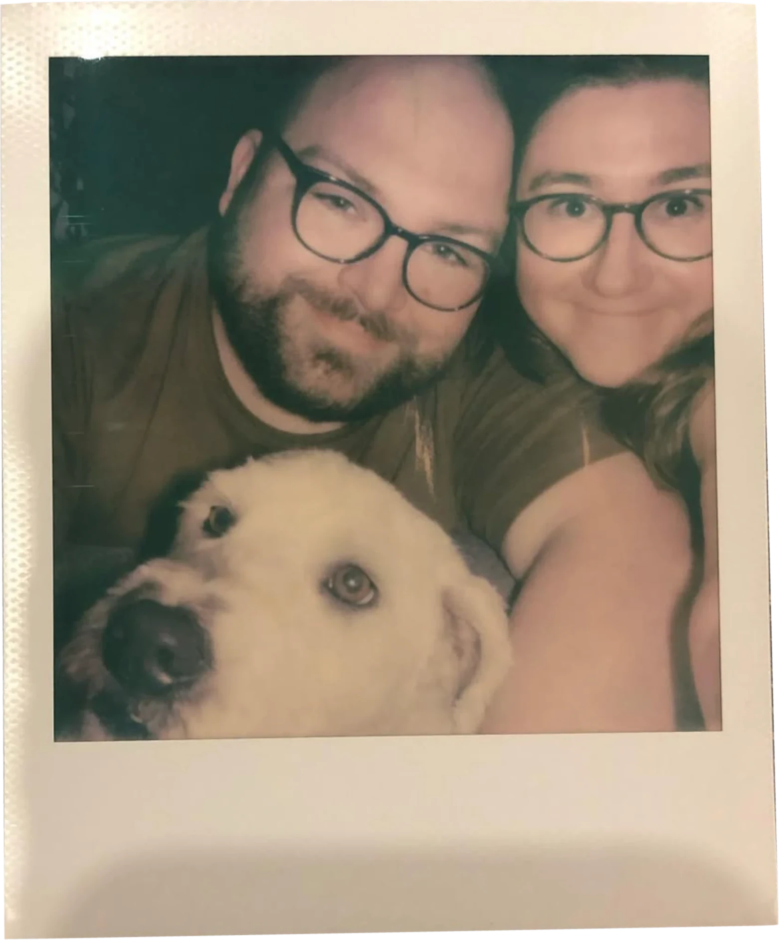 Polaroid selfie of a couple in glasses with their white dog
