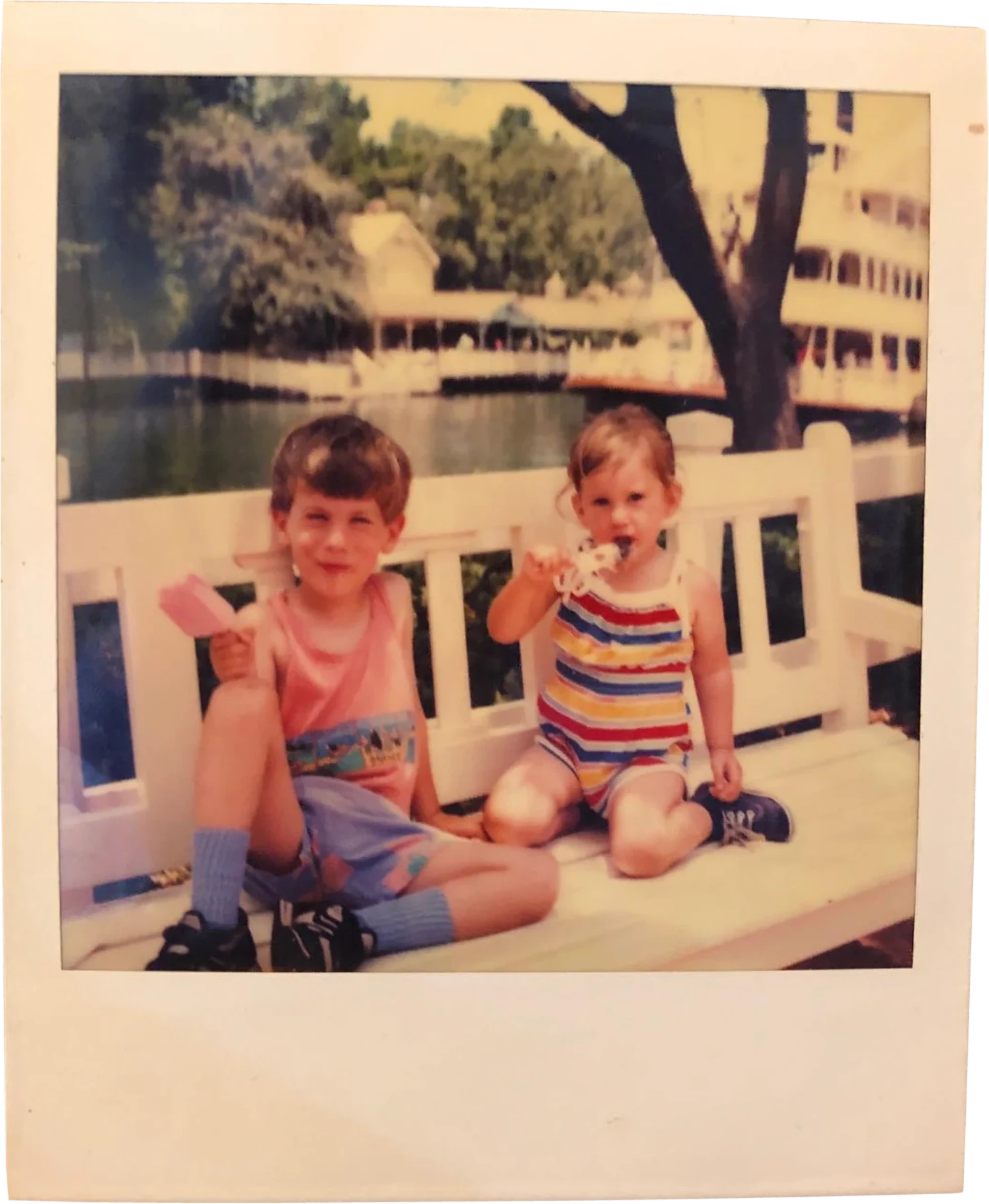 Old Polaroid of two young children eating ice cream on a white bench