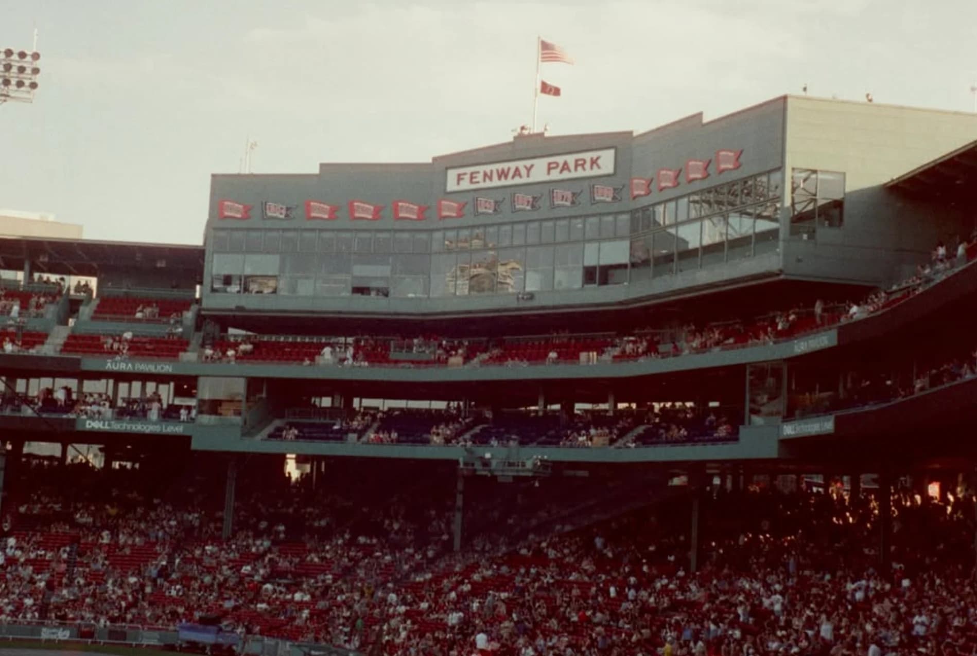 The stands and press box at Fenway Park, full of fans at dusk