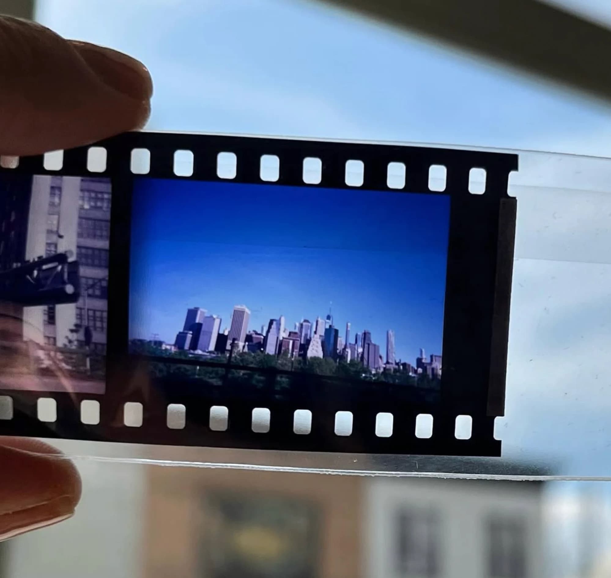 A film strip held up to the light, showing the Manhattan skyline